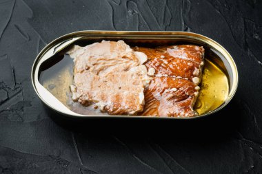Tütsülenmiş somon filetosu konserve balık seti, teneke kutuda, siyah arka planda
