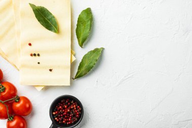 Lazanya hamuru seti, baharat ve şifalı, beyaz taş arka planda, üst görünümde, düz yerde, metin için kopyalama alanı ile