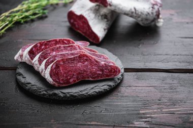 Longaniza, kurutulmuş geleneksel sosis eski ahşap masada dilimlenmiş fotokopi alanı ile..