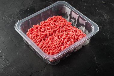 Siyah taş zemin üzerinde şeffaf bir plastik paket seti içinde kıyma, metin için kopyalama alanı