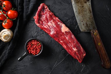 Çiğ pala olarak da bilinen bistro biftek, fajita eti ya da gonglet, yanında pembe biber ve biberiyeli kasap bıçağı. Siyah arka plan. Üst görünüm