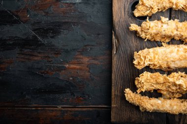 Eski siyah ahşap masa üzerinde kızarmış tavuk budu kesikleri, düz, fotokopi alanı ile..