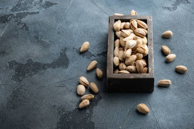 Kabuklu, tuzsuz şam fıstığı, gri arkaplanda mesaj için yer var.