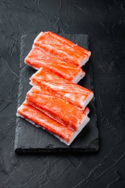Taze Yengeç eti Surimi seti, taş tahtada, siyah arka planda.