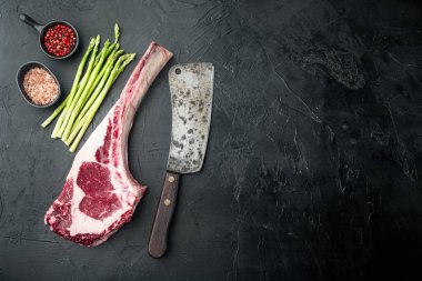 Klasik taze biftek seti, Tomahawk kesimi, siyah taştan arka plan, üst görünüm düz, metin alanı için kopyalama alanı