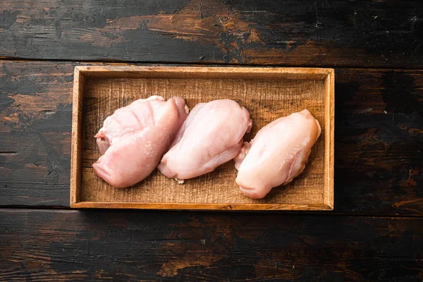 Fresh chicken meat set, in wooden box, on old dark  wooden table background, top view flat lay
