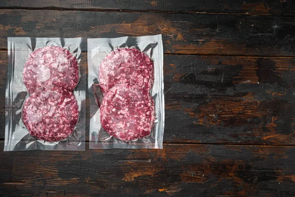 Burger meat vacuum sealed ready for sous vide cooking set, on old dark  wooden table background, top view flat lay, with copy space for text