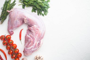 Beyaz taş zemin üzerinde, baharat ve malzeme ile çiğ tavşan eti, üst görünüm düz, metin için kopyalama alanı ile