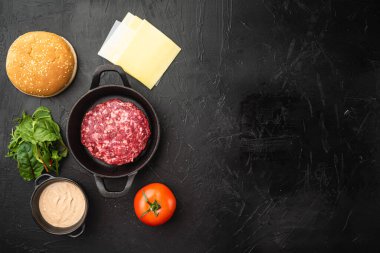 Hamburger bifteği pirzola, malzeme ve çörekler, siyah taş zemin üzerinde, üst görünüm düz, metin için fotokopi alanı
