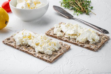 Beyaz taş masa zemininde krem peynirli çıtır ekmek.