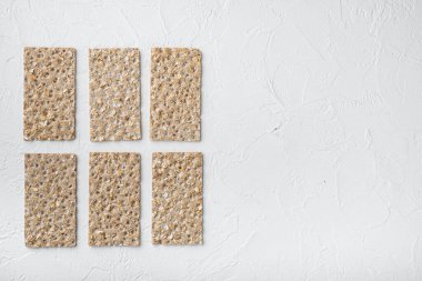 Beyaz taş masa zemininde tam tahıllı çavdar ekmeği kraker seti, üst görünüm düz, metin alanı için kopyalama alanı