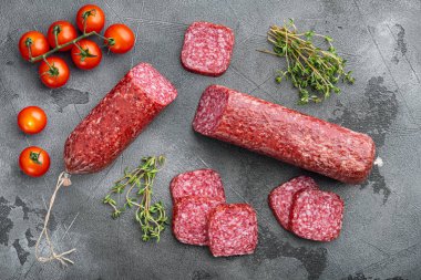 Dilimlenmiş salam seti, gri taş masa arkaplanı, üst görünüm düz yatıyordu