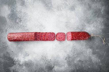 Salam, salam tütsülenmiş sosis, dilimlenmiş sosis, gri taş masa arkaplanı, üst görünüm düz, metin alanı için fotokopi alanı