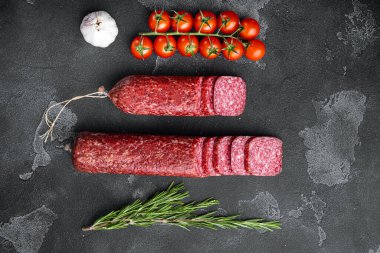 Malzeme seti ile salam, siyah taştan masa arkaplanı üzerinde, üst görünüm düz, metin alanı için kopyalama alanı ile