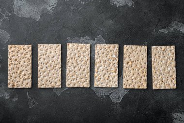 Çıtır çıtır çıtır çıtır. Sağlıklı atıştırmalık seti, siyah taş masa arkaplanı, üst görünüm düz, metin alanı için kopyalama alanı var.