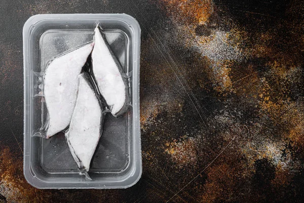 Halibut fish frozen steak pack set, on old dark rustic table background, top view flat lay, with copy space for text