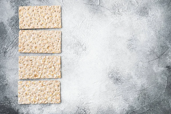 Gri taş masa zemininde, karabuğday gevreği ekmek seti, üst görünüm düz yatay, metin için kopyalama alanı