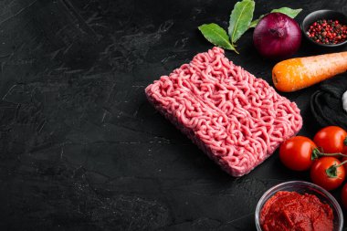 Bolonez sosu malzemeleri, kıyma, domates, bitki seti, siyah taş arka planda, metin için kopyalama alanı