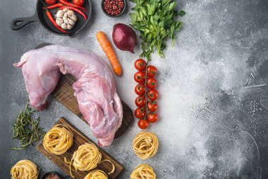 Taze et. Tagliatelle yahnisi pişirmeye hazır bütün tavşan, gri taştan arka planda, düz manzaralı, metin için kopyalama alanı var.