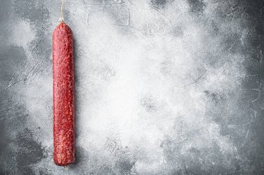 Taze pişmiş sosis salamı seti, gri taş masa arkaplanı, üst görünüm düz yatay, metin için kopyalama alanı ile