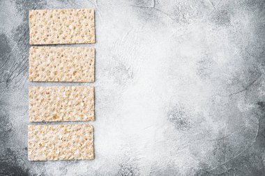 Gri taş masa zemininde, karabuğday gevreği ekmek seti, üst görünüm düz yatay, metin için kopyalama alanı