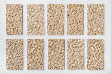 Ayçiçekli çıtır ekmek, chia ve susam tohumları seti, beyaz taş masa zemininde, üst görünüm düz, metin alanı için kopyalama alanı