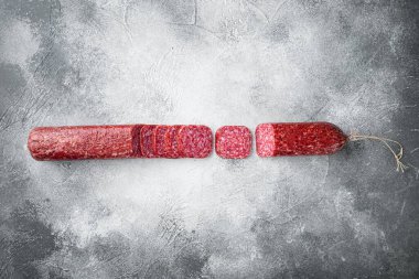 Salam, salam tütsülenmiş sosis, dilimlenmiş sosis, gri taş masa arkaplanı, üst görünüm düz, metin alanı için fotokopi alanı