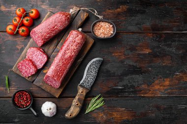 Otlu salam, sarımsak seti, eski koyu ahşap masa arkaplanı, üst görünüm düz, metin için kopyalama alanı ile