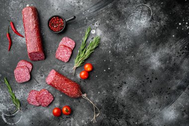 Salam, tütsülenmiş sosis, dilimlenmiş sosis, siyah koyu taş masa arkaplanı, üst görünüm düz, metin alanı için kopyalama alanı