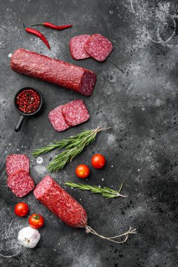 Sosis taze biberiye ve baharatlar seti, siyah taş masa arkaplanı, üst görünüm düz, metin alanı için kopyalama alanı