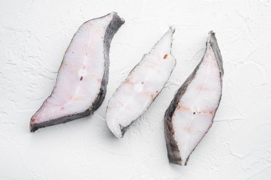 Donmuş balık bifteği seti, beyaz taş masa zemininde, üst manzara düz yatıyordu.