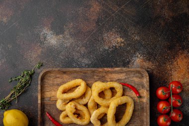 Deep Fried Calamari ya da soğan halkaları seti, servis panosunda, eski koyu kırsal masa zemininde, üst görünüm düz yerde, metin için kopyalama alanı ile