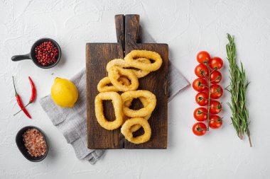 Mürekkep balığı halkaları ya da ekmek kırıntılarında soğan, servis tahtasında, beyaz taş masa zemininde, üst görünüm düz yatıyordu.