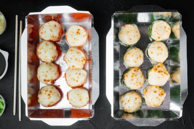 Suşi rulo seti, siyah taş zemin üzerinde, üst görünüm düz yatıyordu