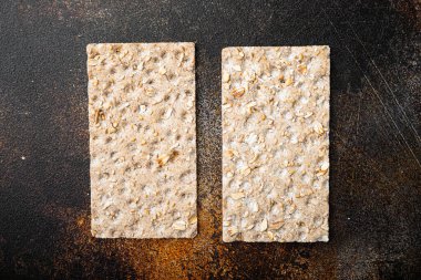 Ayçiçekli çıtır ekmek, chia ve susam tohumları seti, eski koyu kırsal masa arka planı, üst görünüm düz yatıyordu