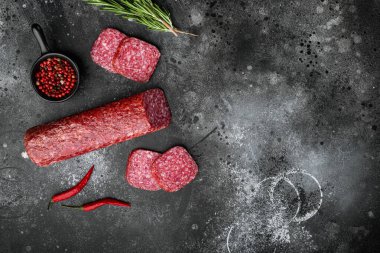 Malzeme seti ile salam, siyah taş masa arkaplan üzerinde, üst görünüm düz yatıyordu