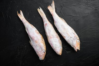 Donmuş sufle balığı seti, siyah taştan masa arkaplanı, üst manzara düz yatıyordu.