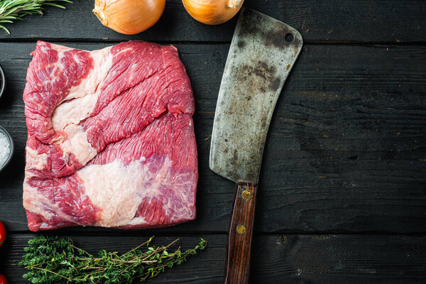 Packer brisket, raw beef brisket meat set,with ingredients for smoking  making  barbecue, pastrami, cure, on black wooden table background, top view flat lay,  with copy space for text