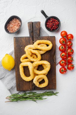 Kızarmış kalamar halkaları. Kızarmış deniz ürünleri seti, servis panosunda, beyaz taş masa zemininde, üst manzara düz yatıyordu.