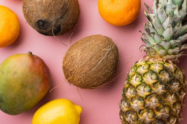 Tropikal meyve seti, pembe desenli yaz arkaplanı, üst görünüm düz yatıyordu