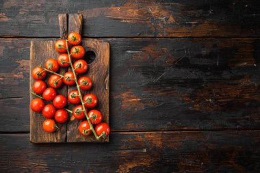Olgun domatesler seti, ahşap kesim tahtası, eski koyu ahşap masa arkaplanı, üst görünüm düz, metin alanı için kopyalama alanı