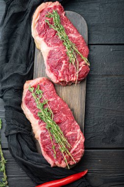Kısa fileto çiğ biftek kesimi, siyah ahşap arka plan, üst görünüm, metin için kopyalama alanı