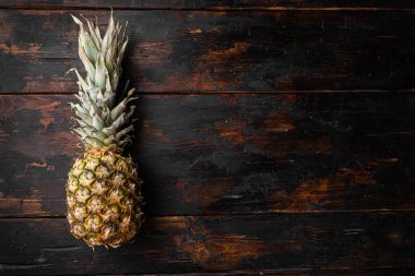 Ananas tropikal meyve seti, eski koyu ahşap masa arkaplanı, üst görünüm düz yatay, metin için kopyalama alanı ile