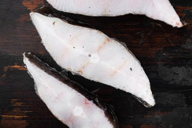 Donmuş beyaz balık filetoları, pollock seti, eski siyah ahşap masa arkaplanı, üst manzara düz