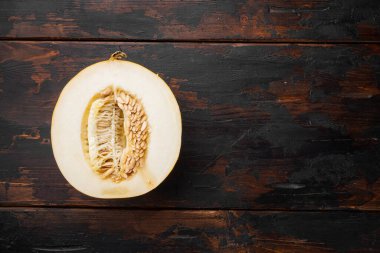 Kavun setinin yarısı, eski koyu ahşap masa arkaplanı üzerinde, üst görünüm düz, metin alanı için kopyalama alanı ile