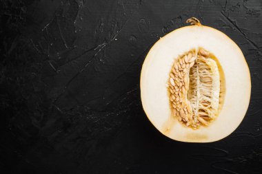 Lezzetli olgun kavun parçaları, siyah taş masa zemininde, üst görünüm düz, metin alanı için kopyalama alanı ile