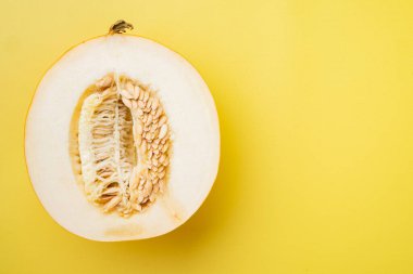 Olgun taze kavun yarım set, sarı desenli yaz arkaplanı, üst görünüm düz, metin için kopyalama alanı ile