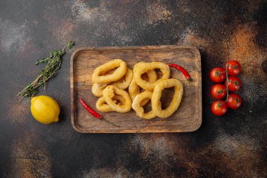Dayak yemiş mürekkep balığının tapa 'sı servis panosunda, eski koyu kırsal masa zemininde, üst görünüm düz yatağında, metin için kopyalama alanı ile dilimlenmiş.
