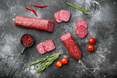 Dilimlenmiş salam seti, siyah taştan masa arkaplanı, en üstteki düz görünüm.