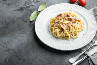 Carbonara makarnası. Pancetta, yumurta, parmesan peyniri setiyle spagetti, gri taş arka planda, metin için kopyalama alanı ile
